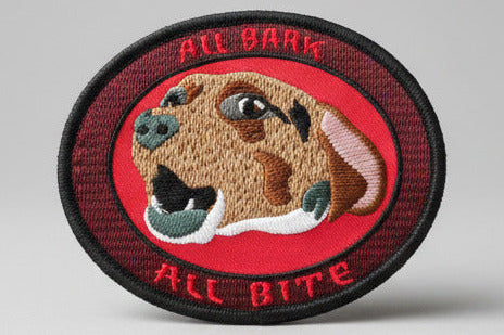 Embroidered patch with a dog's face and 'All Bark All Bite' text on a red background.